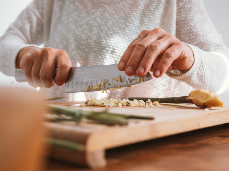 A person chops vegetables in a cooking class.